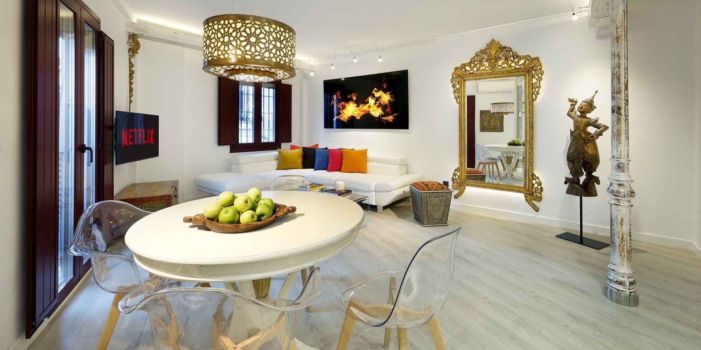 Salón de un piso en el centro de Granada tras una reforma integral, con la columna original restaurada